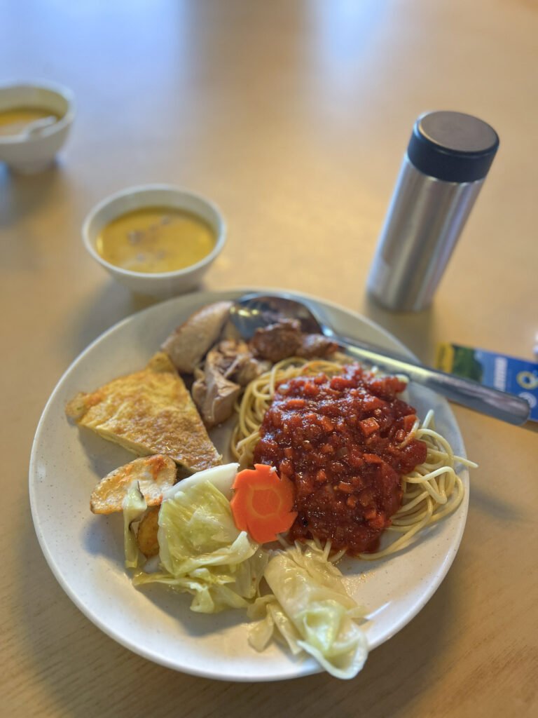 Plate of food from Laban Rata dinner buffet with spaghetti, soup, eggs, vegetables, chicken and beef at Mount Kinabalu Panalaban Base Camp. © SlowingwithT.com
